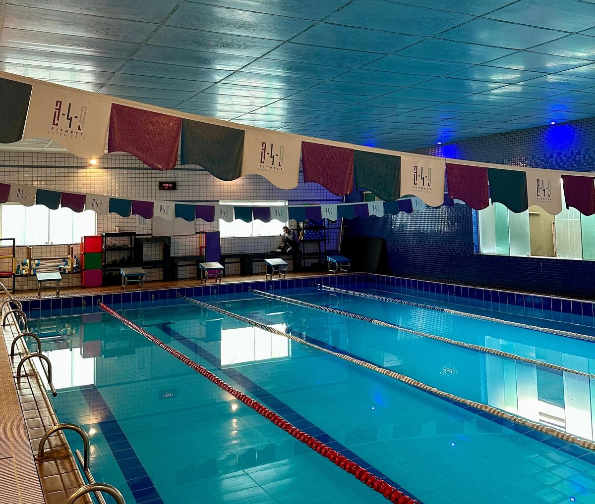 Piscina coberta da 349, com raias demarcadas e bandeiras com o logotipo da 349 penduradas acima da água.